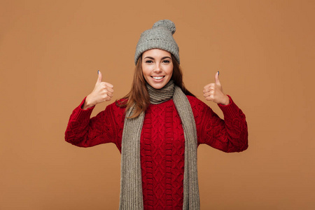 微笑的少妇在冬天衣裳显示竖起大拇指姿态