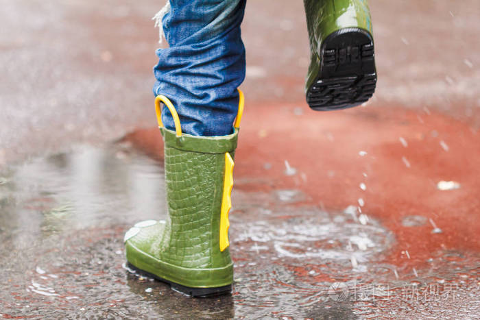 儿童雨靴跳进了水坑里