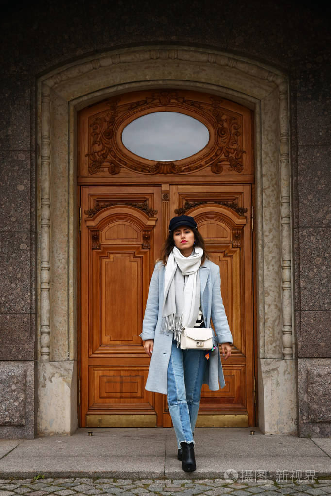 户外的年轻漂亮的时尚女孩在街上摆姿势的全身肖像.模型看相机.