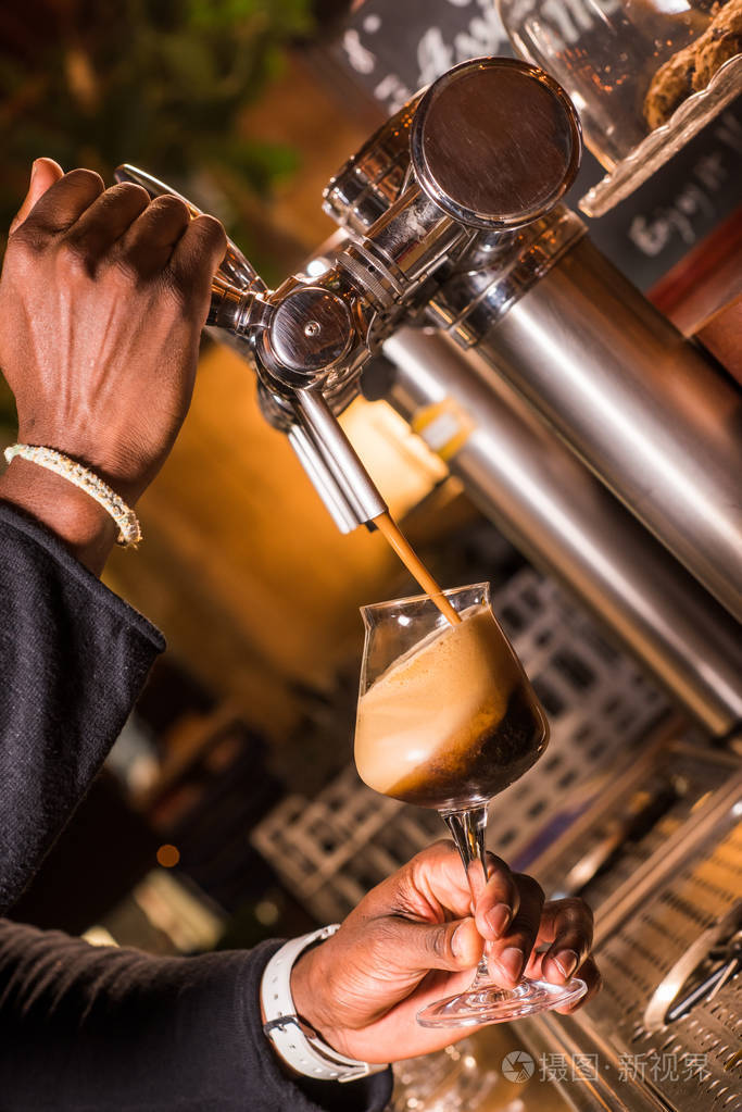 侍者在酒吧里倒啤酒