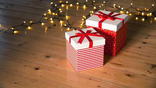 木地板上的红色礼品盒和圣诞灯