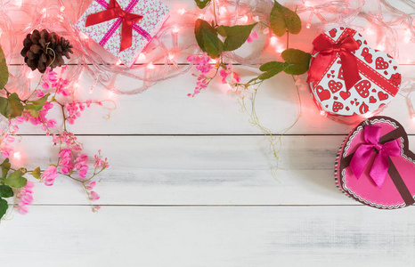 圣诞彩灯与礼品盒和粉红色的花朵
