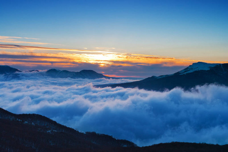 在山上日出.山峰耸立在山顶之上照片
