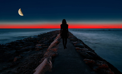 一个女人在海边漫步的剪影 照片