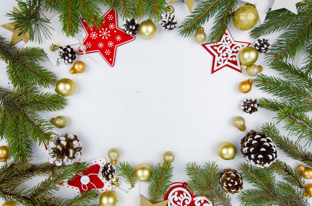 从冷杉树枝和圣诞装饰品的圣诞框架。平躺在白色的木制背景下的圣诞玩具的快乐的新年作文。时尚样机复制空间。顶部视图