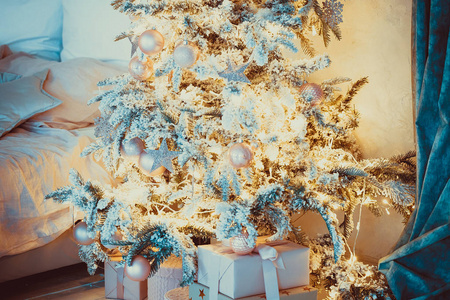 圣诞客厅有圣诞礼物, 圣诞树和床。美丽的新年装饰经典家居内饰。冬季背景