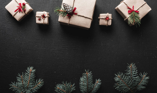 圣诞贺卡对称安排的礼物在顶端和绿色冷杉分支在图象的底部。圣诞祝福留言空间