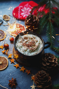 圣诞烟火在一杯热巧克力或可可与棉花糖, 干橙子, 肉桂, 毛皮树, 在黑暗的石头背景手套