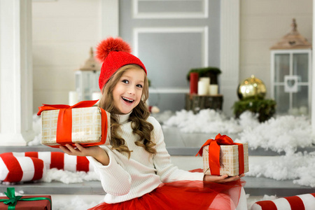 快乐的小女孩拿着很多的礼物盒子。寒假, 圣诞节和人概念