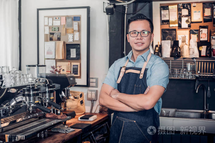 男咖啡店老板跨臂在商店柜台酒吧内c