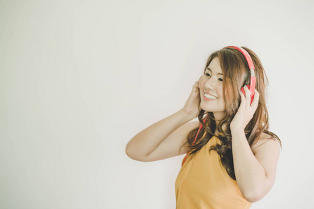年轻漂亮的女人戴着耳机听音乐