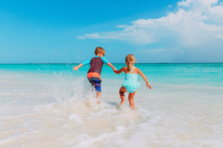 小男孩和女孩在海滩奔跑玩水
