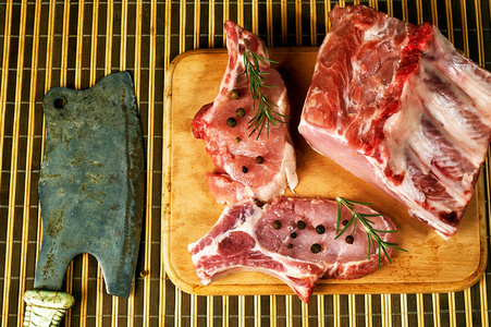 生牛排, 排骨, 肉用香料和蔬菜在木桌上