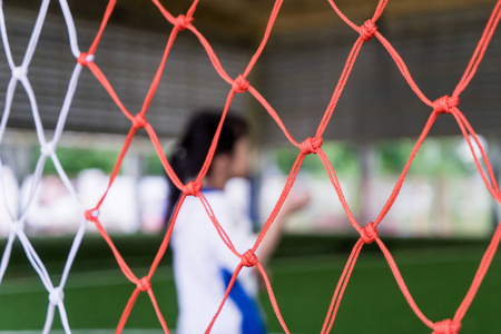 儿童足球运动员在足球球门网前面模糊