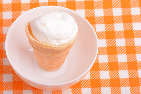 香草冰淇淋勺橙纸背景