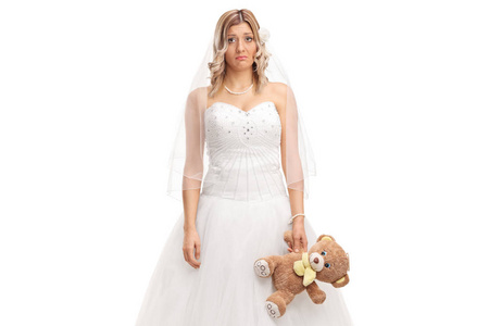 悲伤的新娘紧握着一只泰迪熊