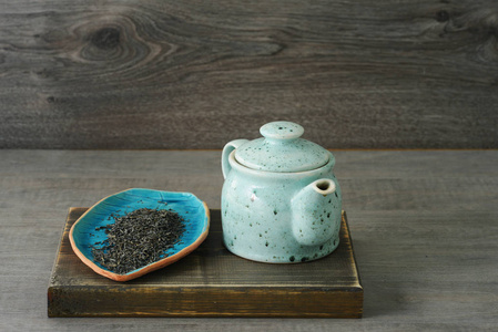 木制背景的蓝色陶瓷茶壶
