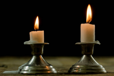 蜡烛在木桌上的烛台上燃烧。银色蜡烛