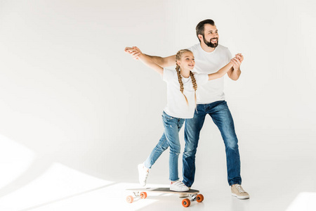 父亲和女儿与滑板