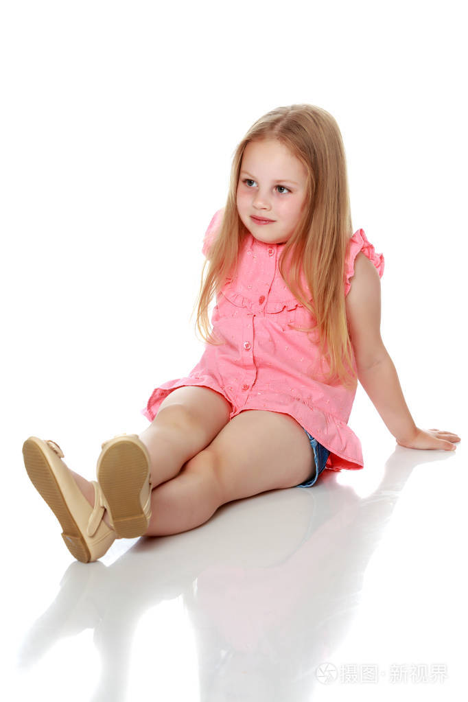 小女孩正坐在地板上