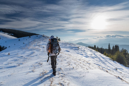 男人正在冬天的山上背包旅行