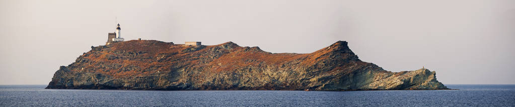 科西嘉 日落在 Giraglia, 海岛在北部末端科西嘉在地中海, 著名为它的灯塔和热那亚塔, 两个是历史纪念碑
