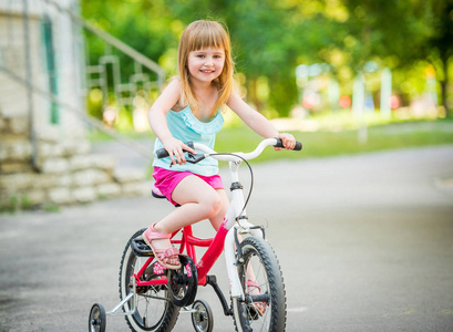 美丽的微笑的小女孩骑自行车