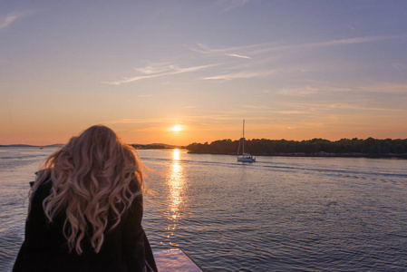 帆船日落之旅女人在各岛之间的日落时分乘船旅行照片