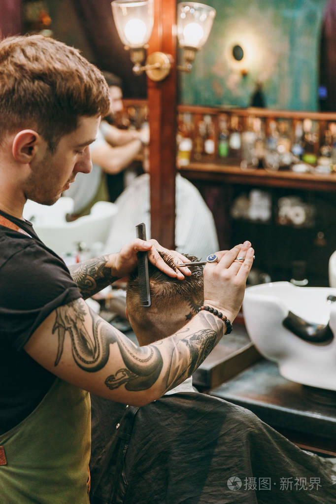 男性发型师在纹身服务客户