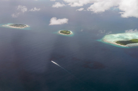 热带海岛和环礁在马尔代夫在印度洋从空中看法。切割波浪船。地球上的一块天堂。度假的好选择。美丽的壁纸顶部视图
