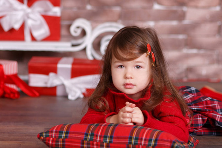 年轻的黑发女郎女孩时髦穿着红色礼服服装契克斯格子裙子皮带鞋微笑摆在工作室圣诞树与噘嘴和粉红色的脸颊