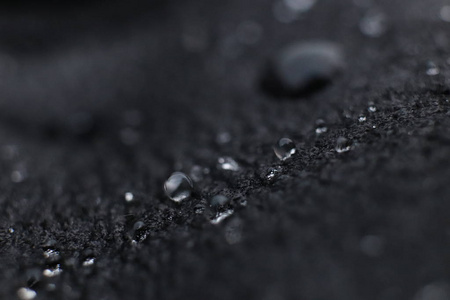 水滴在黑色皮革背景纹理。宏特写镜头