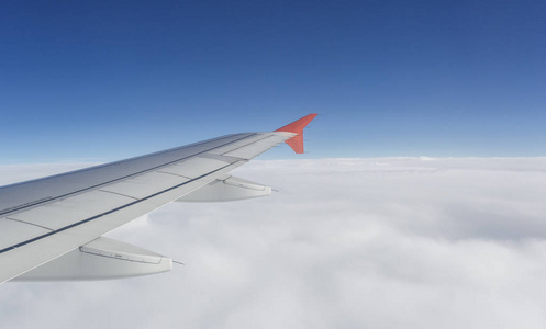 多云天空与翼的飞机视图从照明灯