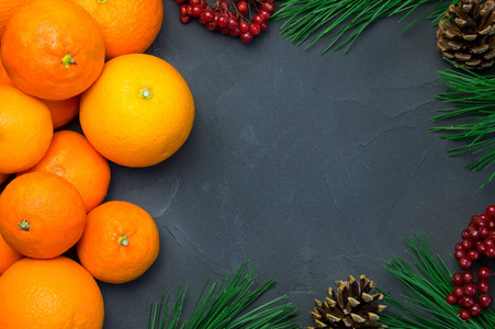 橙色和橘色与分支圣诞树和 ashberry 在黑色混凝土背景