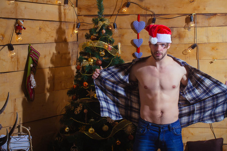 有肌肉胸部的木制背景的圣诞节男子