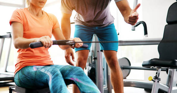 私人教练协助女性在健身房减肥