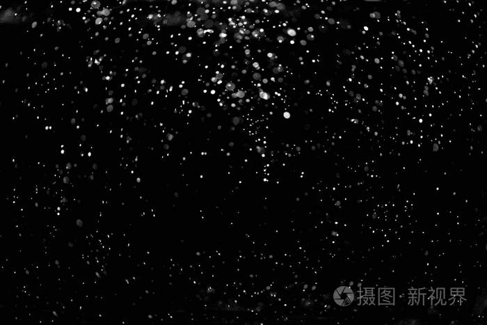 黑色背景下飘落的雪花
