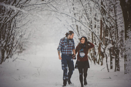 幸福的夫妇在冬季公园散步