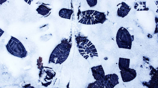 雪地里有肮脏的脚印从靴子上的轨道