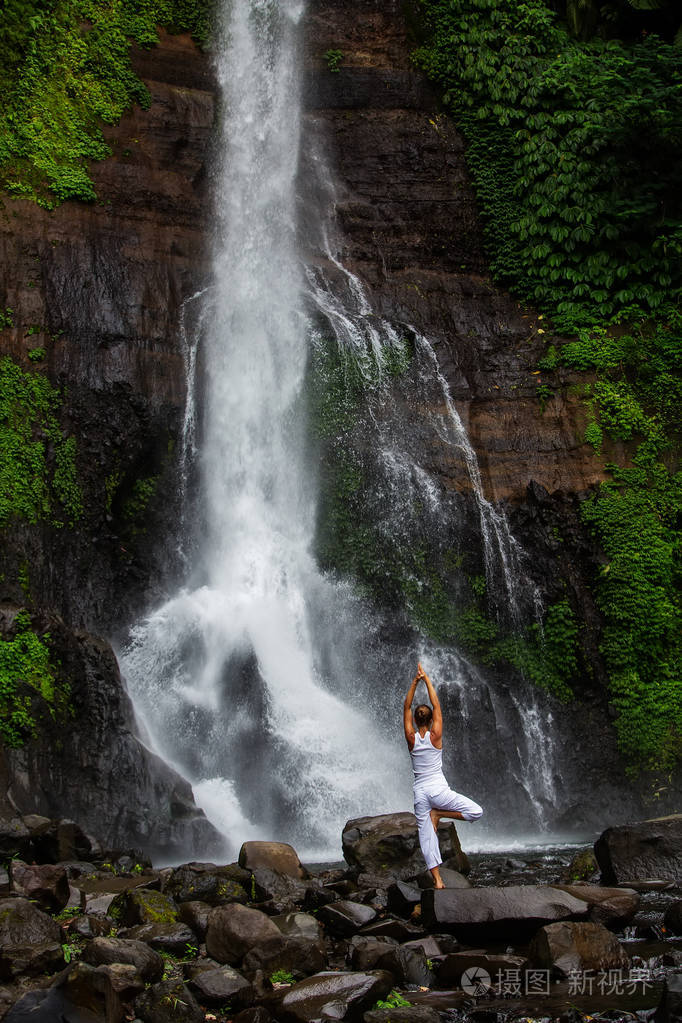 印度尼西亚巴厘岛gitgit瀑布的妇女练习瑜伽