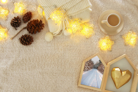 绑扎毛衣, 松树锥, 金色的心和驯鹿在舒适和毛皮地毯。斯堪的纳维亚风格的设计。顶部视图