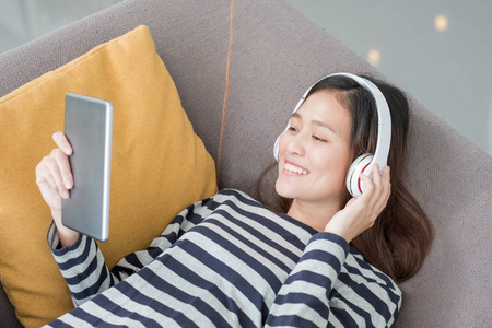亚洲青少年女孩戴耳机听音乐播放与选项卡