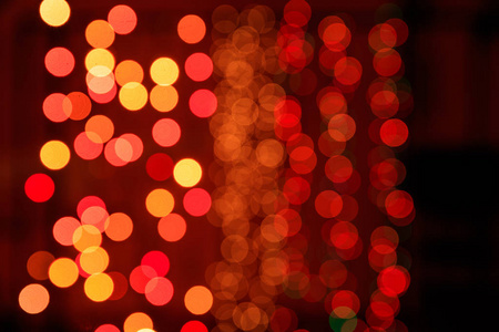 圣诞灯饰背景。橙色黄色和红色指示灯在黑色背景
