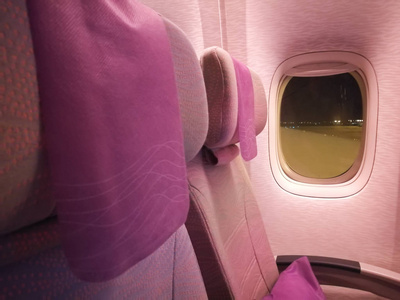 飞机的粉红色经济座椅在晚上