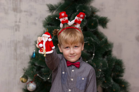 圣诞节前圣诞树上摆着圣诞饰品的小男孩