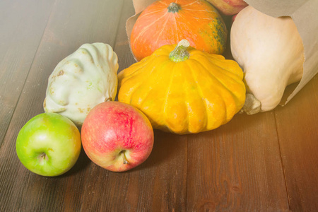 秋天自然概念。秋天南瓜和苹果在木制的质朴的桌子上。感恩节晚餐
