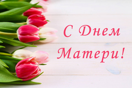 粉红色的郁金香在一个白色的木桌上, 在俄罗斯快乐的母亲节题词