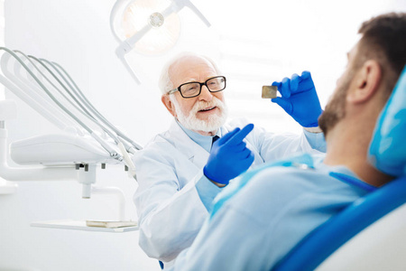 兴奋的 stomatologist 演示 x 射线图像的病人照片