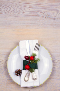 在木制的地方, 用盘子餐具松树枝肉桂和红浆果等圣诞套装。冬季假期和节日背景。圣诞前夕晚餐, 新年食品午餐