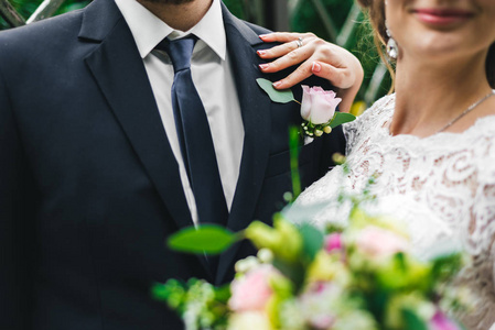 妇女在一个长的白色礼服与婚礼花束一起与新郎